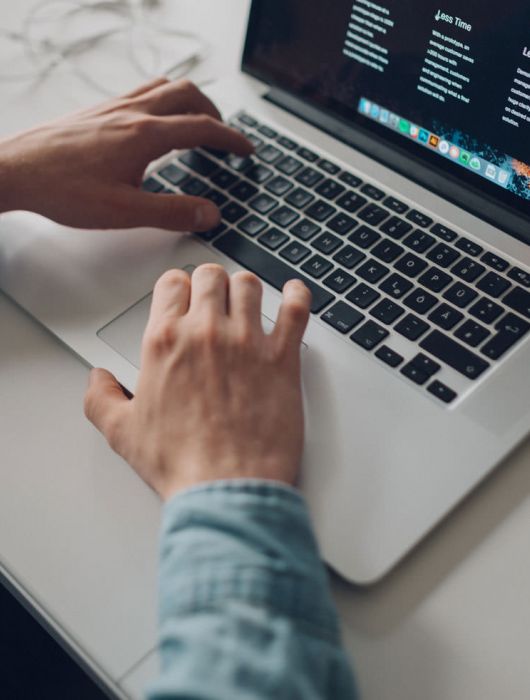 Mann tippend auf Laptop